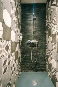 GrazacLe Dôme et son jacuzzi的一间带淋浴的浴室和瓷砖墙