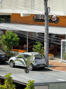 阿拉亚尔-杜卡布Suítes Viver Arraial do Cabo的停在餐厅前的白色汽车
