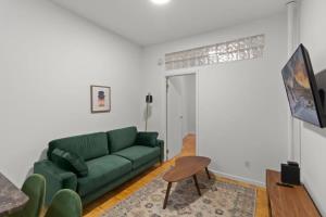 纽约Cozy 1BR in the Upper East Side的客厅配有绿色沙发和桌子