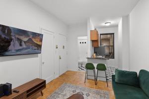 纽约Cozy 1BR in the Upper East Side的客厅配有沙发和两把绿色椅子