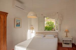 皮索利瓦迪Villa Armonia的卧室配有白色的床和窗户。