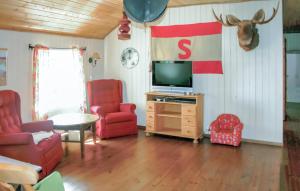 法尔松Lovely Home In Farsund With Wi-fi的客厅配有电视和红色椅子