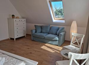 基什孔毛伊绍Cottage im Natur-Resort Pool, Schwimmteich & Sauna的客厅设有蓝色的沙发和窗户。