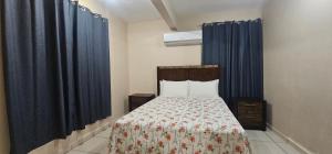阿瓜达Discovery Beach Apartments的一间卧室配有一张蓝色窗帘的床