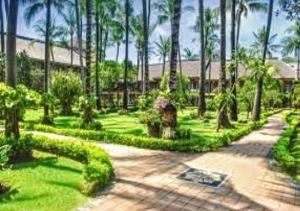 塞米亚克Suite Hotel Apartment Legian by RCP的种有棕榈树和步道的花园