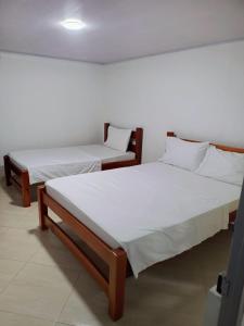比亚维森西奥Hotel Zarina的配有白色床单的客房内的两张床