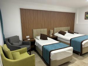 博德鲁姆丁奇膳食公寓的酒店客房,配有两张床和椅子
