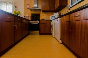 七城WelcomeBuddy - Casa dos Avós - Garden & Lake II的厨房设有木制橱柜和橙色瓷砖地板。