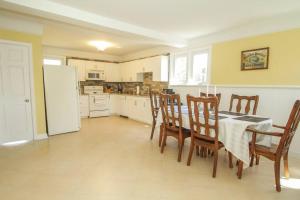 康沃尔Homey Single Family on Old Orchard的厨房配有桌椅和冰箱。