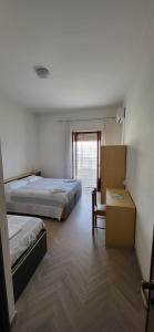 佩斯基奇Da Carlino的一间卧室设有两张床、一把椅子和一个窗户。