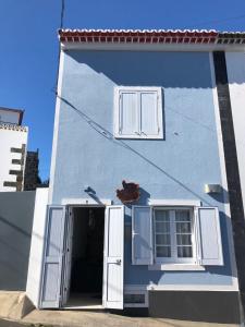 卡罗拉WelcomeBuddy - Uma Casa na Caloura - Blue & Beach的蓝色和白色的建筑,设有门窗