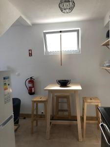 卡罗拉WelcomeBuddy - Uma Casa na Caloura - Blue & Beach的厨房配有桌子、两张凳子和窗户
