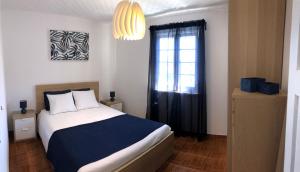 卡罗拉WelcomeBuddy - Uma Casa na Caloura - Blue & Beach的一间卧室设有一张大床和一个窗户。