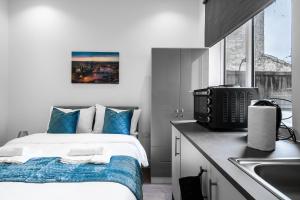 伦敦Modern Studio Rooms in Wembley的一间卧室配有一张带蓝色枕头和水槽的床