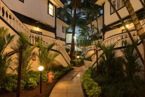 巴加2 Bedroom Apartment in Resort on Candolim Beach的棕榈树建筑旁的走道