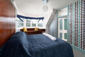 伊尔弗勒科姆Westwell Hall的一间卧室配有蓝色的床和两个枕头