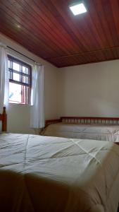 坎波斯杜若尔当Casa boa vista的一间卧室设有两张床和窗户。