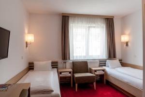 布雷根茨布鲁格旅馆的配有一张床和一把椅子的酒店客房