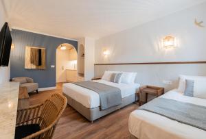 阿尔戈斯托利翁蓝色天堂一室公寓的酒店客房设有两张床和一张桌子。