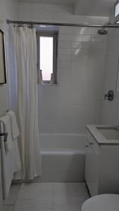 纽约The Central Park West by Amsterdam Avenue的白色的浴室设有淋浴帘和水槽