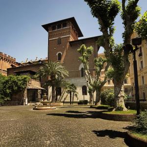 罗马Hotel Ercoli House的前面有树木的大型砖砌建筑