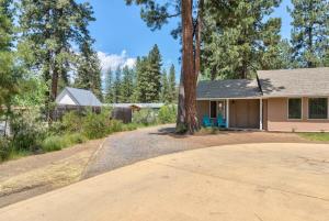 本德Private Cottage Near Scenic Deschutes River Woods!的车道上有一棵树的房子