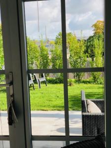 翁弗勒尔Bel Air Studios-Terrasse couverte-Jardinet-Vue Pont de Normandie-Parking privé的享有庭院景致的滑动玻璃门