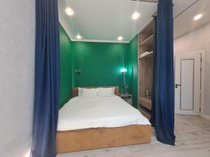 阿斯塔纳INJU Arena 1-rooms apartments的一间卧室设有一张大床和绿色的墙壁