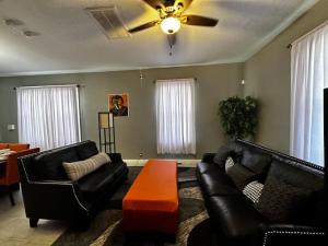 落基山Renovated,Comfortable and Convenient Experience的客厅配有黑色皮革家具和吊扇