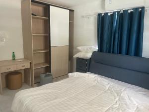 KoolbaaiSunny apartment 2的一间卧室配有床和蓝色窗帘