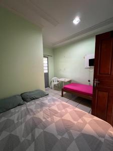 里约布兰科Hotel Shalon的一间卧室配有一张大床和一张粉红色的长凳