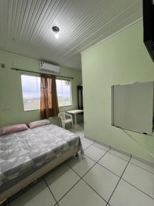 里约布兰科Hotel Shalon的一间卧室配有一张床和一台平面电视