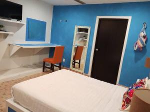 梅里达T´úubul K´iin Bed & Breakfast的一间卧室设有一张床和蓝色的墙壁