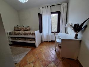 La MateaEl Pinar de la Lobera的一间卧室配有一张床、一张书桌和一个窗户。