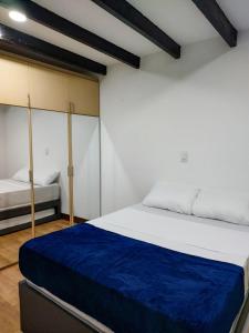 圣罗莎德卡瓦尔Casa La Riviera的一间卧室配有一张带蓝色毯子的大床