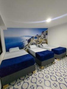 圣罗莎德卡瓦尔Casa La Riviera的一间设有三张床的房间,并画着海洋