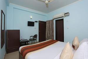 新德里Oyo Hotel Luxury Inn Near Dhaula Kuan Delhi的配有一张床和一张书桌的酒店客房