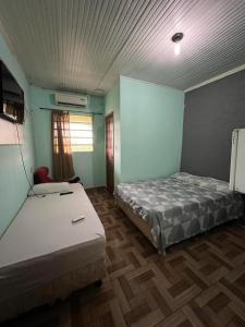 里约布兰科Hotel Shalon的配有蓝色墙壁和木地板的客房中的两张床