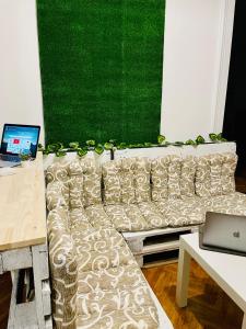 诺维萨德Hostel Green World的客厅配有沙发和带笔记本电脑的桌子