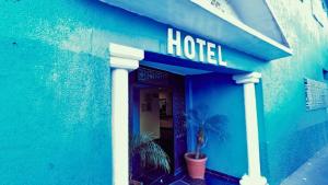 墨西哥城Hotel Plaza San Juan的蓝色的建筑,上面有酒店标志