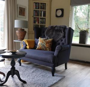 埃尔默洛Hof van Benten的客厅配有蓝色椅子和桌子
