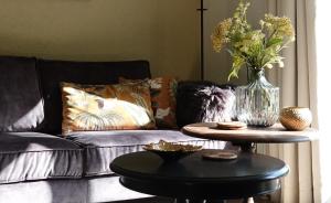 埃尔默洛Hof van Benten的客厅配有沙发和带花瓶的桌子