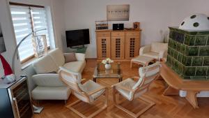 基姆湖畔布赖特布伦Chiemsee-Ferienhaus Schlegel的客厅配有白色椅子和电视