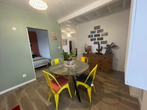 Villenyla Casa d'Olianna - Jolie Maison / Jeux / Grand jardin的一间带桌子和黄色椅子的用餐室