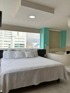 库库塔亚瑟布里奇酒店的一间卧室设有一张大床和一个浴缸