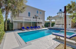 棕榈岛Endless Summer by AvantStay Across From Beach Ocean Views的一个带蓝色椅子的游泳池