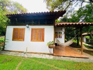贝洛奥里藏特Casa de Campo Pampulha的白色的小房子,设有木甲板