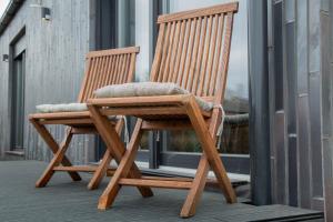 KortenbergMeerbeek Unwind的阳台上配有两张木制摇椅