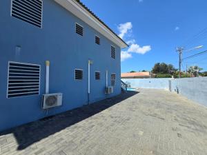 威廉斯塔德库拉索卡特兰公寓的蓝色的建筑,旁边是砖砌的人行道
