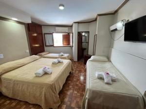 特尔马斯德里奥翁多Hotel Santander的酒店客房设有两张床和一台平面电视。